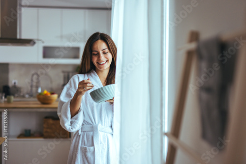 Woman Enjoying Breakfast in Modern Kitchen Wearing Cozy Bathrobe