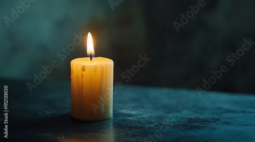 A single candle burning on a dark blue surface. Warm and inviting.