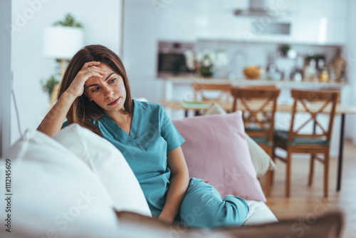 Tired Nurse Resting on Sofa in Modern Kitchen Environment