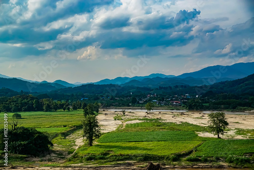 Serene landscape view of mountainous terrain and agricultural fields rural area nature photography cloudy skies scenic beauty