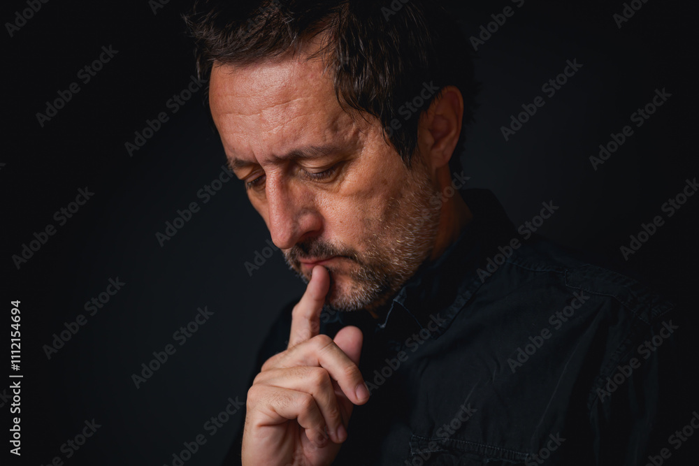 Portrait of tired mature adult man thinking in dark room Portrait of tired mature adult man thinking in dark room
