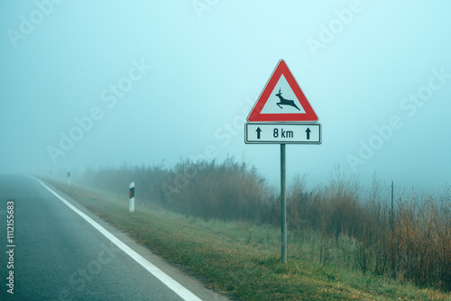 Wild animals In road traffic sign on foggy morning photo