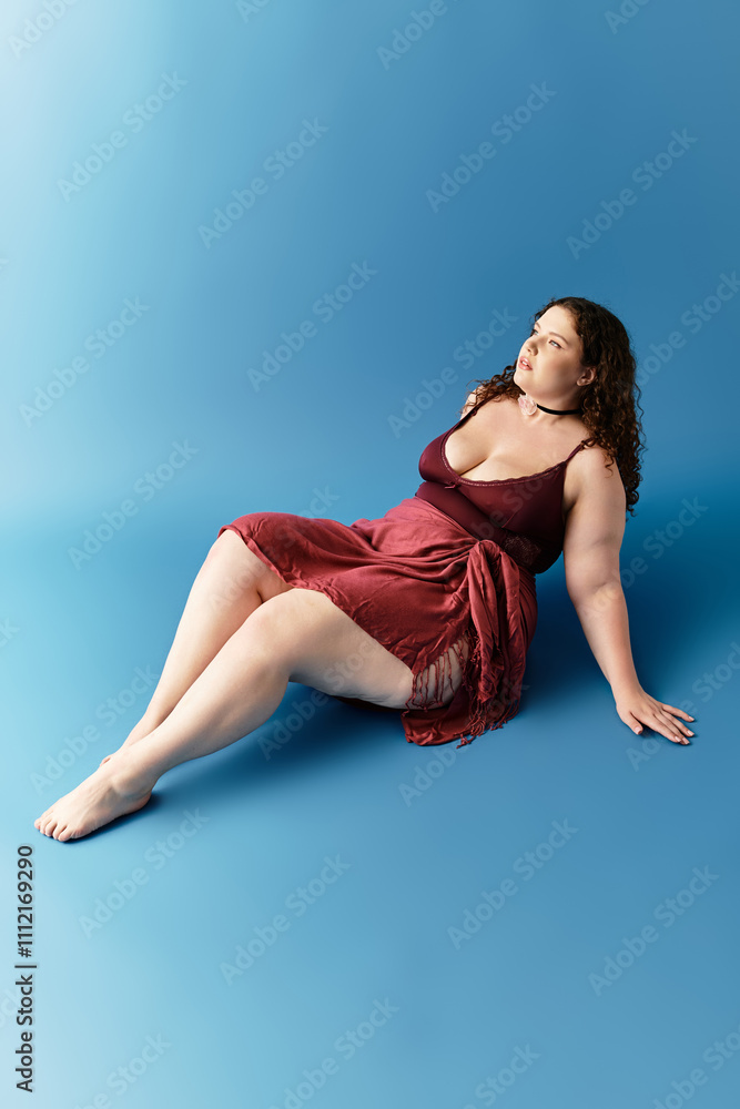 A young woman in a chic dress strikes a confident pose on a bold blue background. A young woman in a chic dress strikes a confident pose on a bold blue background.