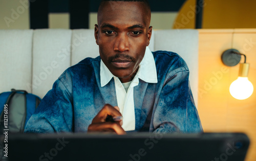 Принти на полотні Focused male student studying in a library, concentrating on his work with deter