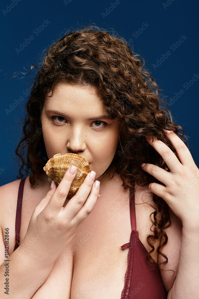 A young woman enjoys a seashell snack while showcasing her trendy outfit and unique style. A young woman enjoys a seashell snack while showcasing her trendy outfit and unique style.