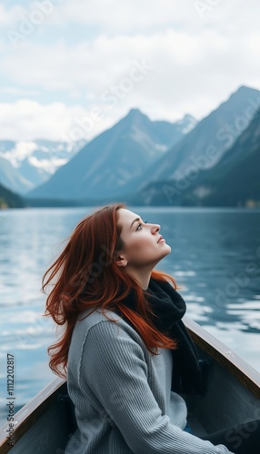 A woman with red hair is sitting in a boat on a lake