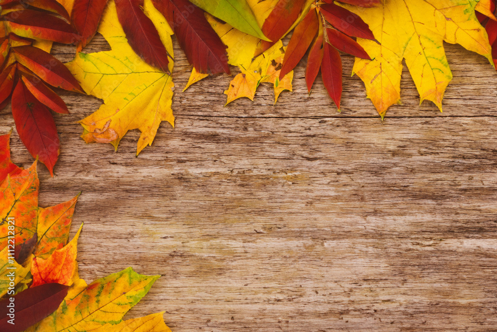 Obraz premium Autumn leaves on a wooden background. Wooden autumn leaves on a wooden background. Autumn leaves wooden background colored lies. Wooden leaves lying on a wooden background in lifestyle autumn.