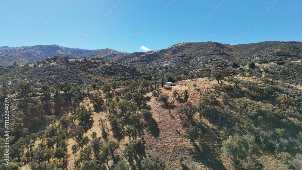 Aerial view of scenic hilly landscape under a clear blue sky. Aerial view of scenic hilly landscape under a clear blue sky.