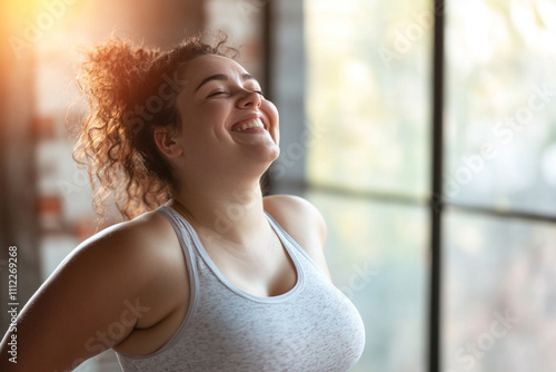 Happy overweight woman doing exercises in the gym