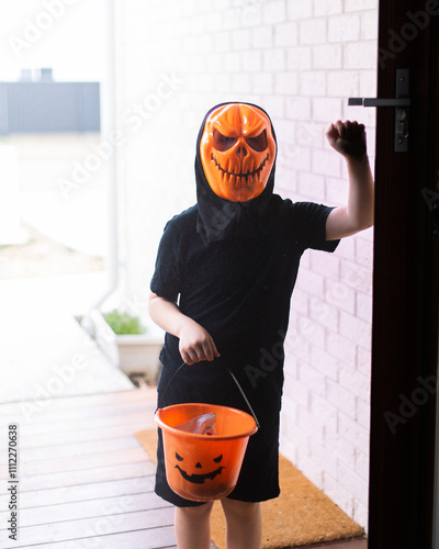 masked child trick or treating on halloween