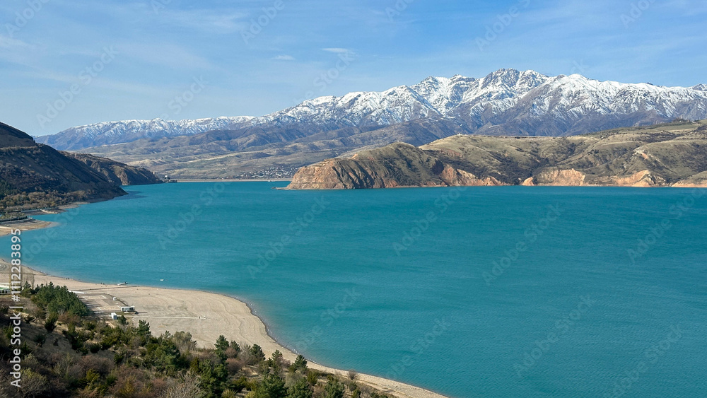 reservoir in the mountains with snowy peaks