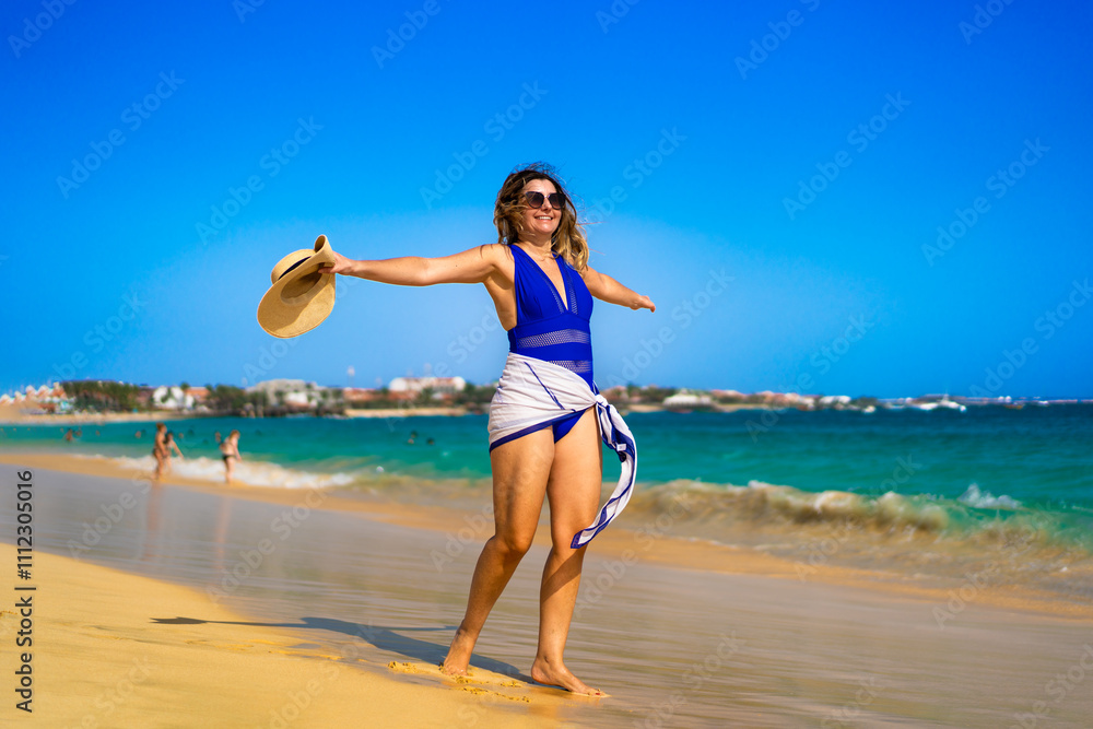 Beautiful mature woman walking on sunny beach Santa Maria, Sal Island, Cape Verde Beautiful mature woman walking on sunny beach Santa Maria, Sal Island, Cape Verde