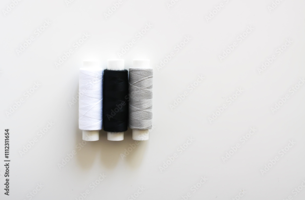 Many colorful sewing threads on light background. Many colorful sewing threads on light background.