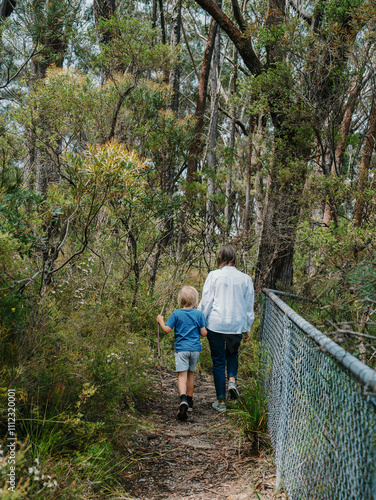 Grandmother spending time with grandson in nature walking along track photo