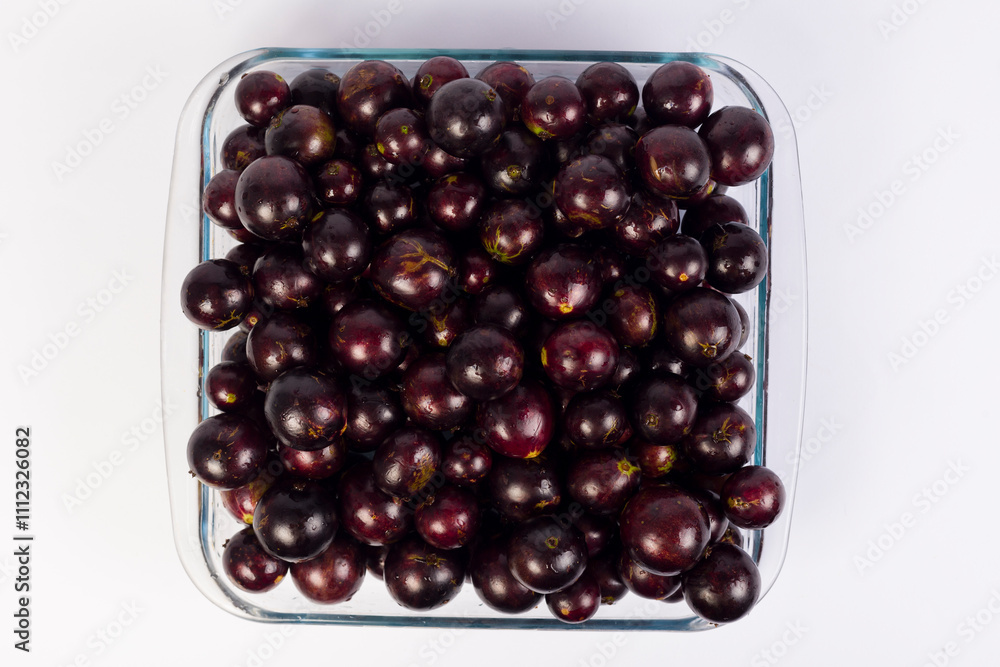 transparent Bowl full of Brazilian fruit jabuticabas on a white background transparent Bowl full of Brazilian fruit jabuticabas on a white background