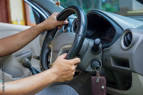 Hands gripping a steering wheel inside a car, ready for a drive.