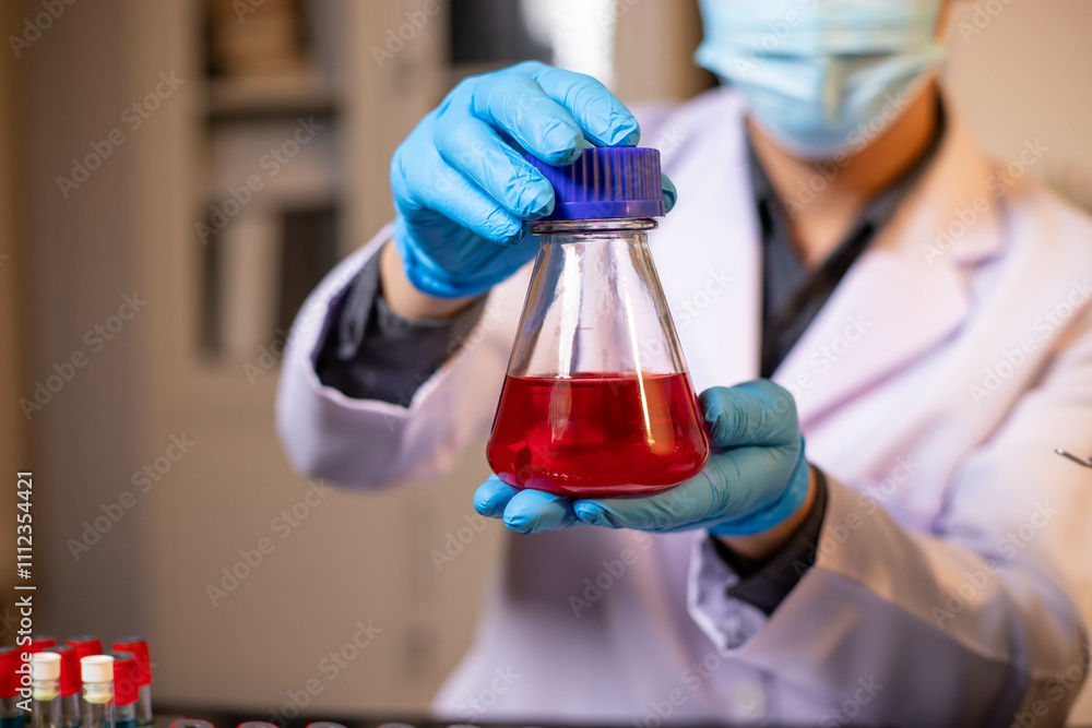 Human hand in glove holding glass jar in modern laboratory. Close-up and long exposure photography. Human hand in glove holding glass jar in modern laboratory. Close-up and long exposure photography.