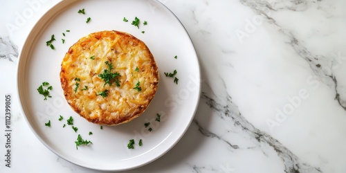 Tortino di Patate potato cake plated on a clean white plate, smooth marble background, top view, reserved space for text.
