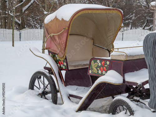 A light semi-open carriage for transporting passengers with the help of a horse. The britzka is standing in a snowdrift. An antique stroller. photo