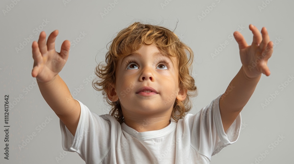 The image depicts a young child with curly hair wearing a white shirt and gazing upwards with their arms Outstretched. The image depicts a young child with curly hair wearing a white shirt and gazing upwards with their arms Outstretched.