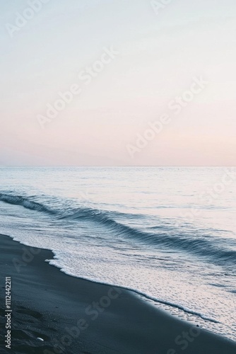 Serene beach scene at sunset with gentle waves and soft colors.