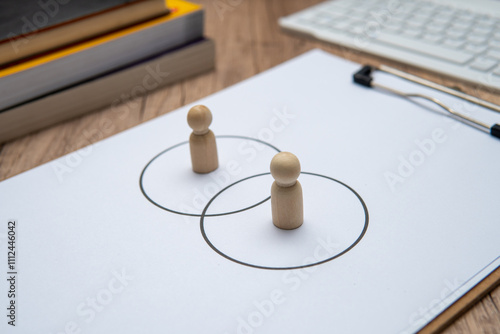 Fotografi Two wooden figures standing in separate circles overlaps with each other
