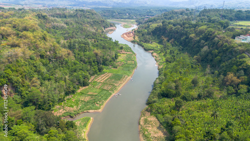 Aerial View of the Citarum River with Green Waters Surrounded by Agricultural Land and Forests in Indonesia photo