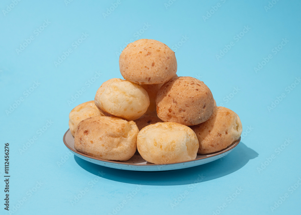 stack of Cheese bread on the plate, Brazilian pao de queijo mineiro, blue background stack of Cheese bread on the plate, Brazilian pao de queijo mineiro, blue background