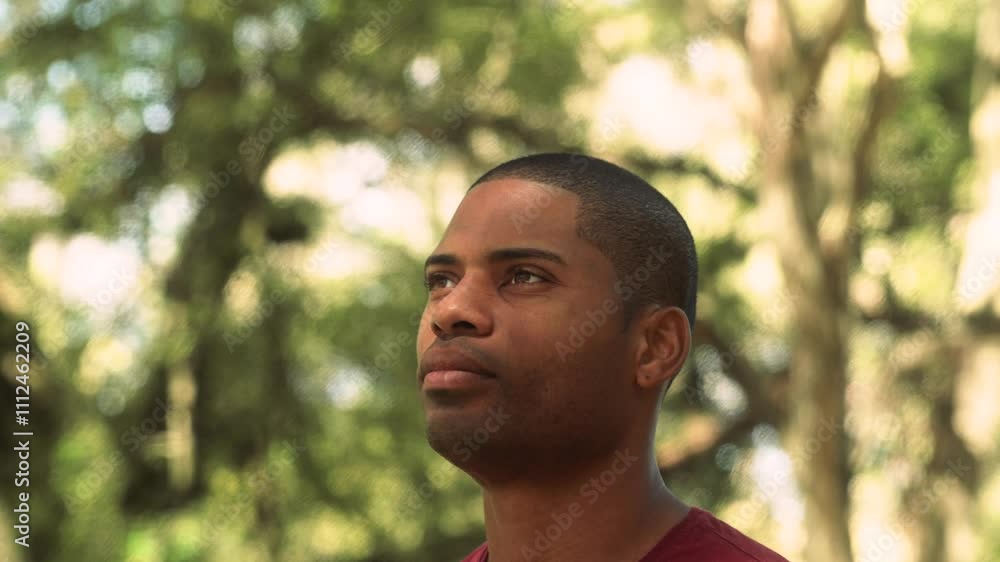 Serene African American man standing still and taking in the peaceful atmosphere of the forest. Relaxed male in casual clothes enjoying a moment of mindfulness and connection with nature Serene African American man standing still and taking in the peaceful atmosphere of the forest. Relaxed male in casual clothes enjoying a moment of mindfulness and connection with nature