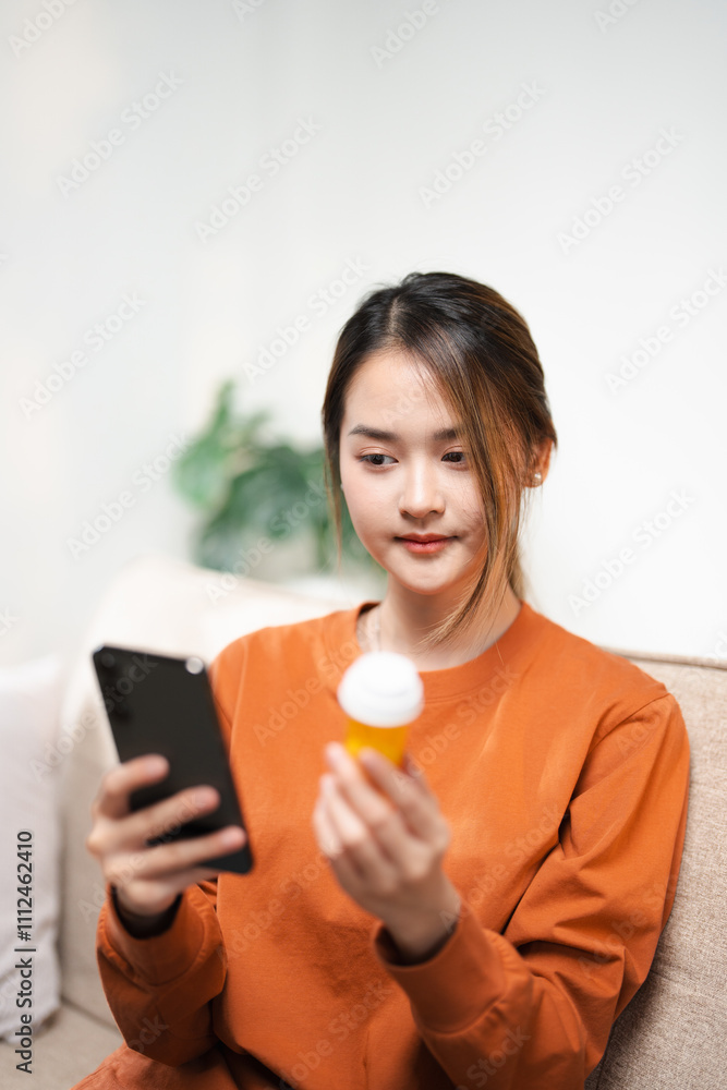 Health care asian young woman using smart phone for reading, searching prescription on bottle medicine, pill label text about information online, instructions side effects, medicament concept. Health care asian young woman using smart phone for reading, searching prescription on bottle medicine, pill label text about information online, instructions side effects, medicament concept.