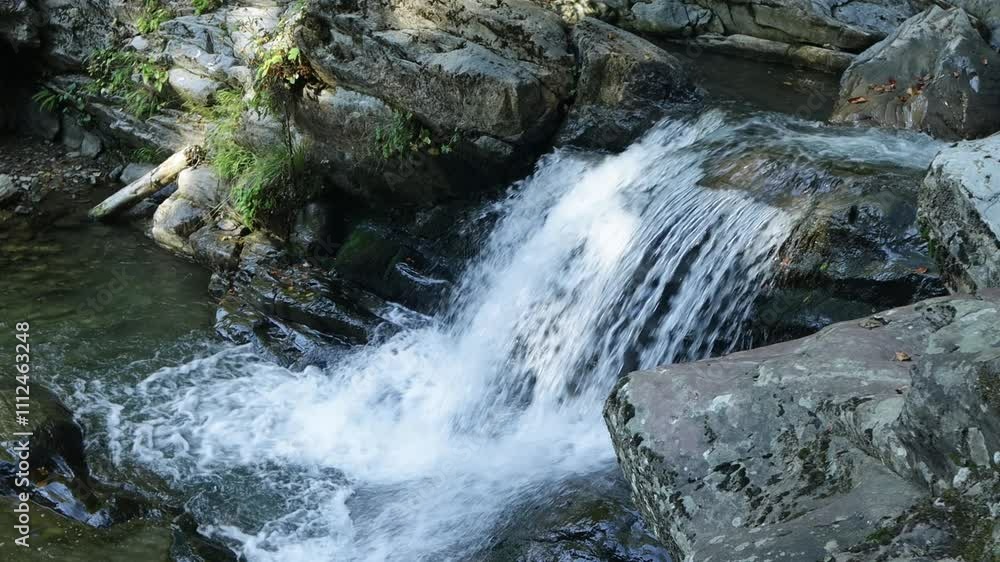 waterfall in the mountains on a sunny day waterfall in the mountains on a sunny day