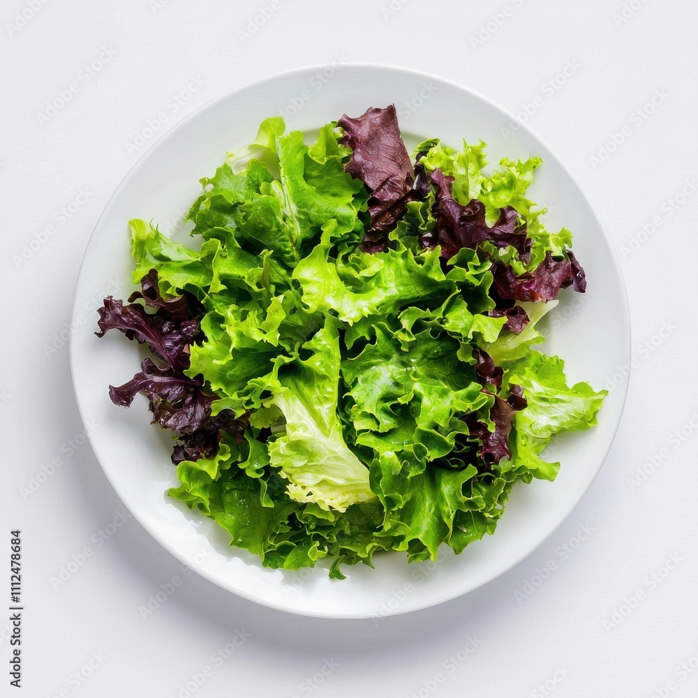 Fresh green and purple lettuce leaves on a white plate, isolated on a white background. Fresh green and purple lettuce leaves on a white plate, isolated on a white background.