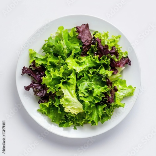 Fresh green and purple lettuce leaves on a white plate, isolated on a white background. photo