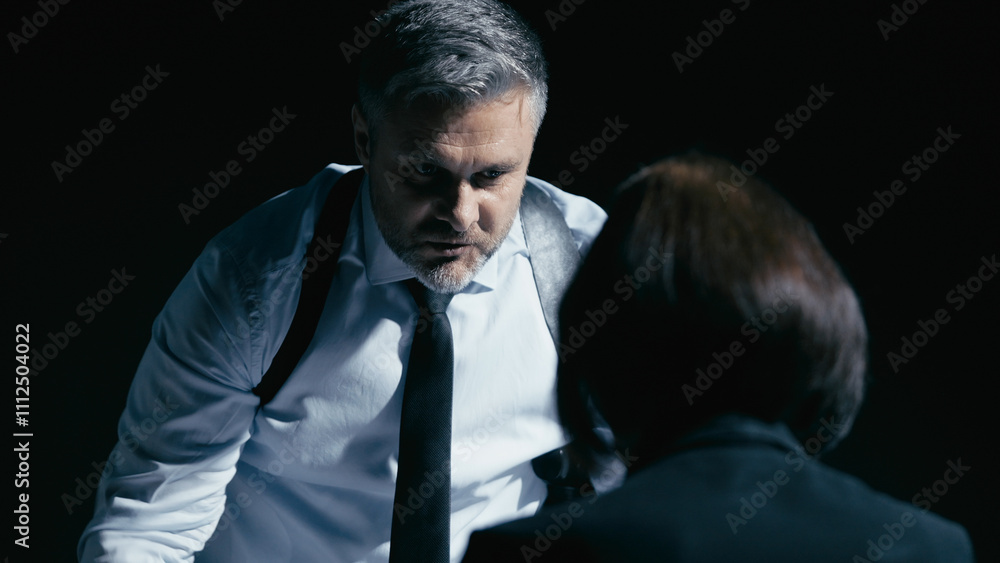 Fototapeta premium Aggressive police detective intimidates the suspect, describing incriminating evidence