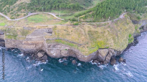 The beautiful harmony of Songaksan Dulle-gil, the sea, and cliffs in Jeju Island, Korea, and the natural scenery taken from the sky with drones