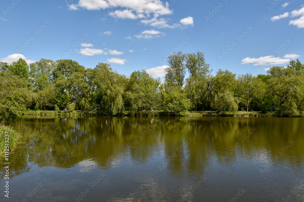 Summer reflections on calm ponds surrounded by lush greenery in Piaseczno Summer reflections on calm ponds surrounded by lush greenery in Piaseczno