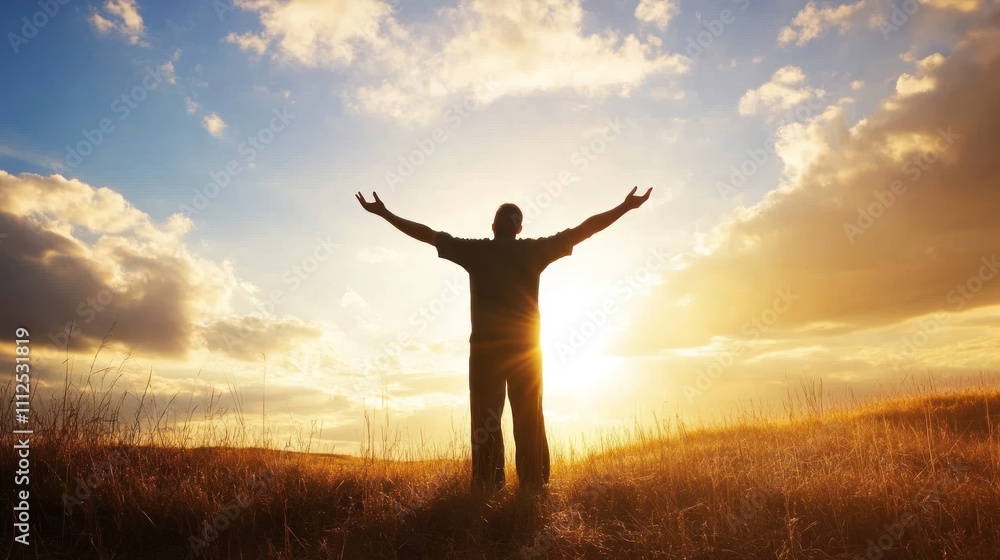 Person with open arms stands before a setting sun Person with open arms stands before a setting sun