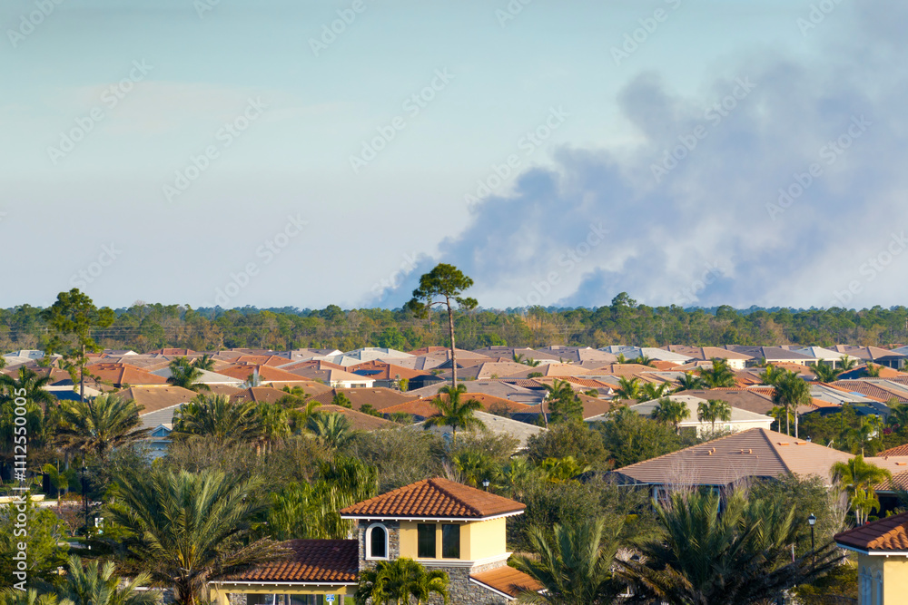 Obraz premium Air contamination with burning smoke from prescribed fire close to suburban area in Florida, USA