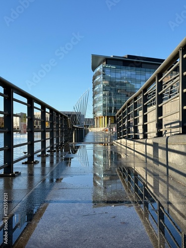 Canvas Print Walkway with metal fencing and reflections in the water
