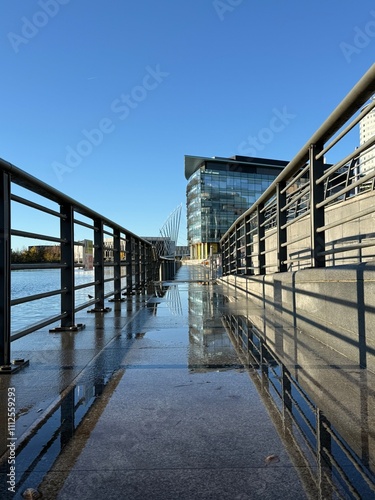 Canvas Print Walkway with metal fencing and reflections in the water