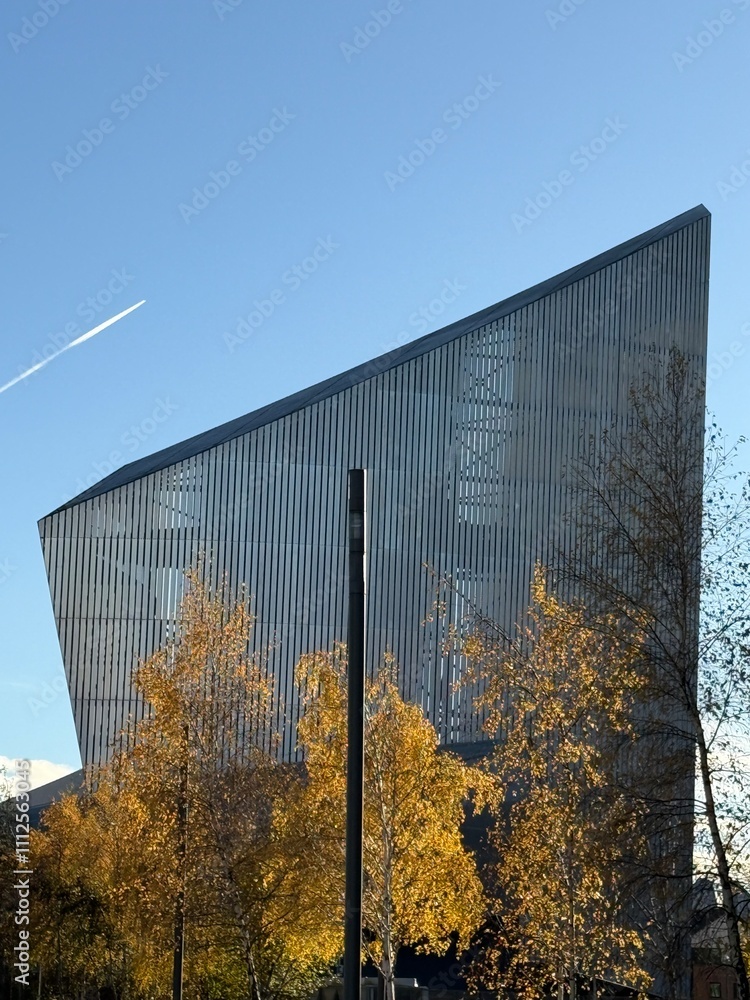 Modern building with trees in the front and a clear blue sky background. Taken in Salford Quays Manchester England. Modern building with trees in the front and a clear blue sky background. Taken in Salford Quays Manchester England.