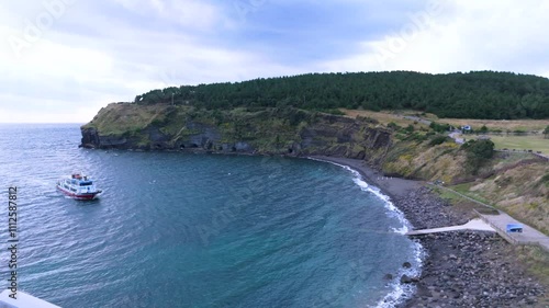 The beautiful harmony of Songaksan Dulle-gil, the sea, and cliffs in Jeju Island, Korea, and the natural scenery taken from the sky with drones