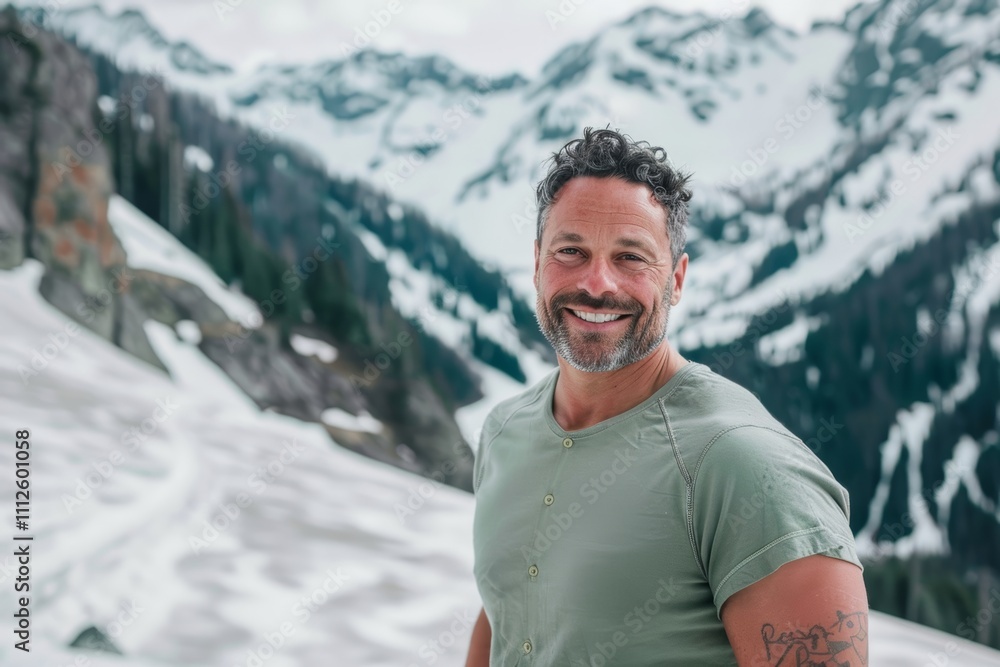 Portrait of a glad man in his 40s donning a trendy cropped top in front of snowy mountain range Portrait of a glad man in his 40s donning a trendy cropped top in front of snowy mountain range