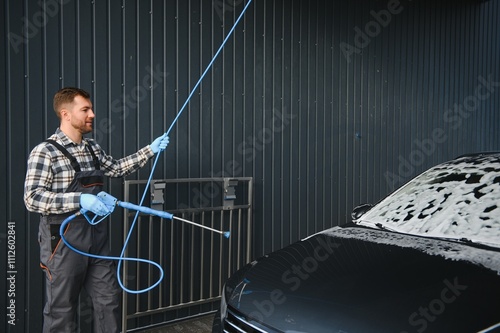 Car Wash Specialist Using Pressure Washer to Rinse a car photo