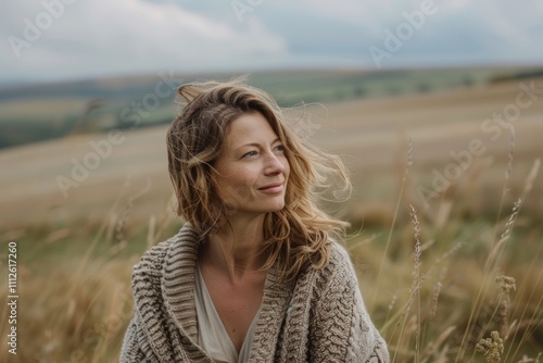 Portrait of a satisfied woman in her 30s wearing a chic cardigan over quiet countryside landscape