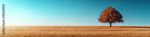 Solitary tree in vast field under clear blue sky, symbol of solitude and peace