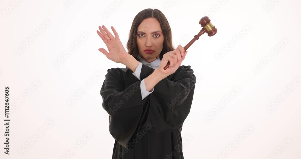 Woman judge with gavel demonstrates Stop gesture on white background. Female magistrate represents law authority power in legal context Woman judge with gavel demonstrates Stop gesture on white background. Female magistrate represents law authority power in legal context