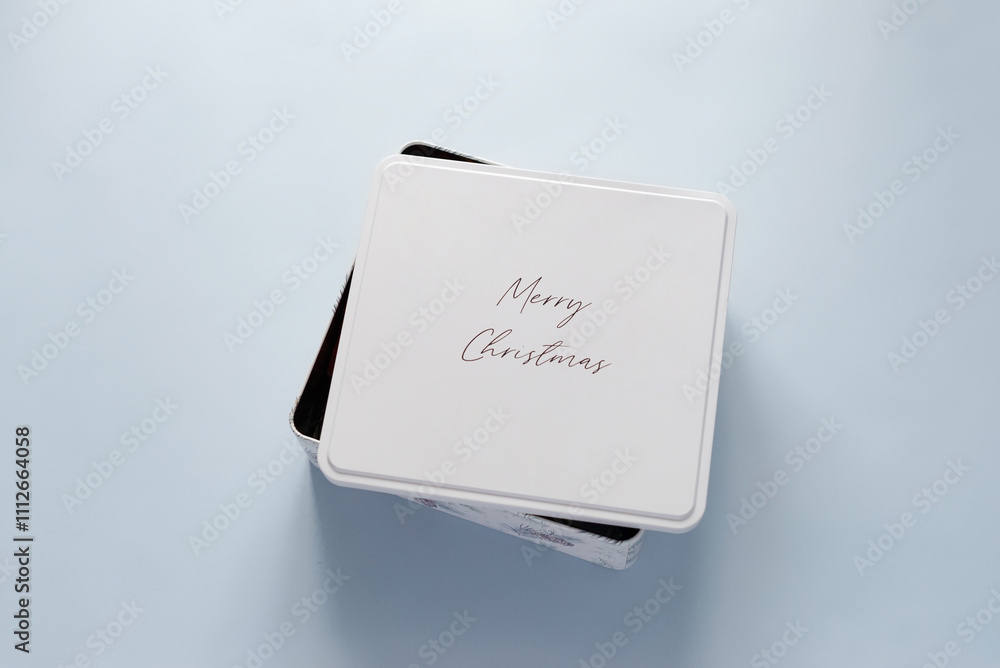 White Christmas gift box on light blue background with space for text or design. Present for Christmas or Saint Nicholas Day on a minimal background, top view White Christmas gift box on light blue background with space for text or design. Present for Christmas or Saint Nicholas Day on a minimal background, top view