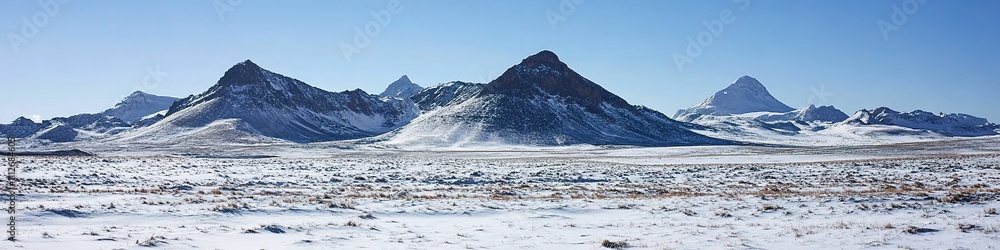 Snow-capped mountain range under blue sky, vast tundra in front Snow-capped mountain range under blue sky, vast tundra in front