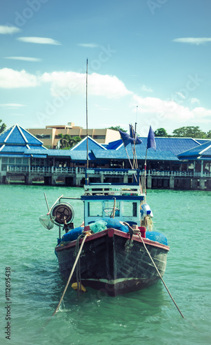 A blue boat is parked against a background of blue houses